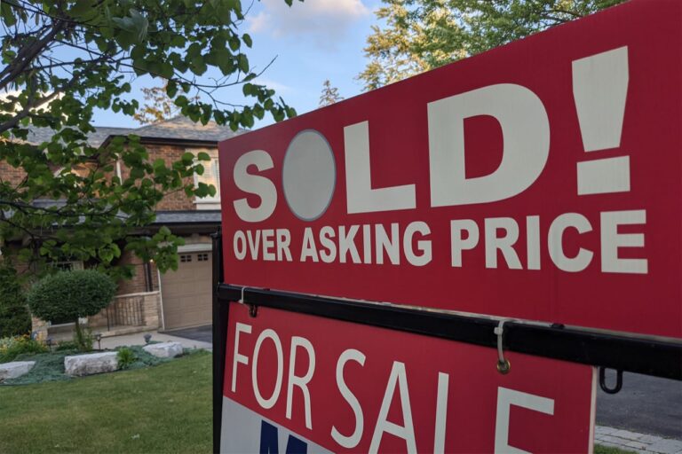 New sign sold over asking price for sale in front of detached house in Ontario.