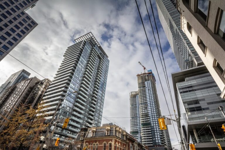 Toronto, Canada - Modern skyscrapers in a bustling downtown CBD highlight North American commercial growth, global investment, and evolving corporate landscapes under a bright urban sky.
